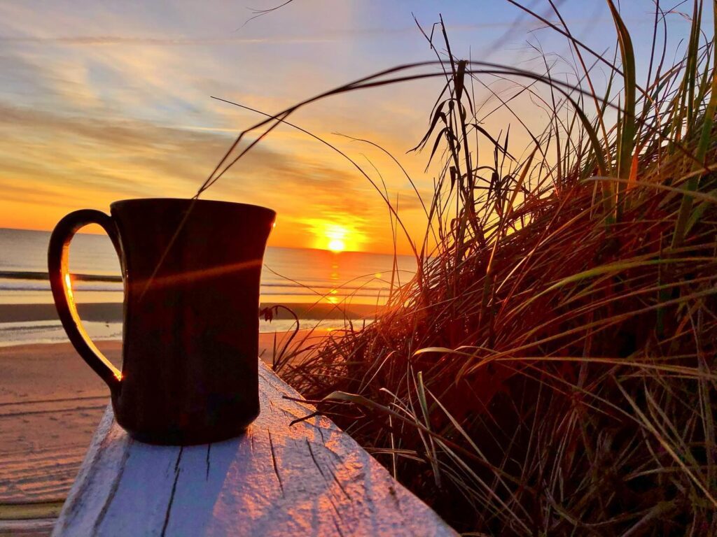Corolla NC beach at sunset with family walking along shoreline relaxed Outer Banks evening
