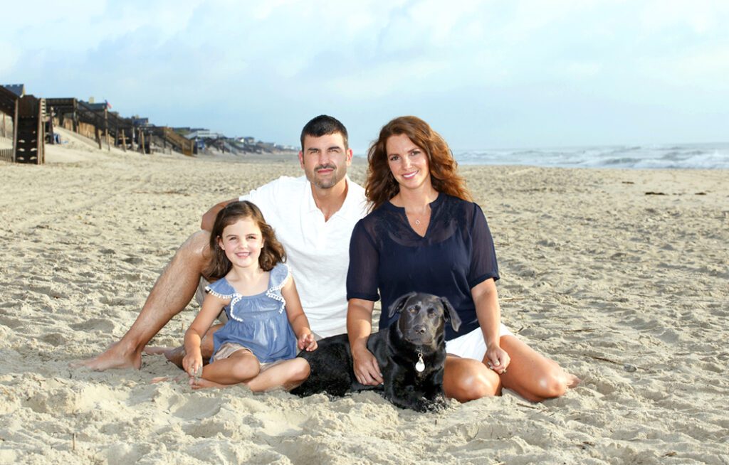 Corolla family photographer capturing family portrait with dog on beach