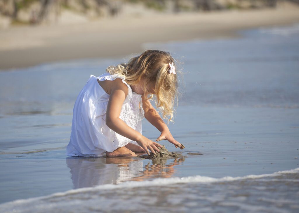 a lifestyle photo of a girl playing on the beach in corolla, nc