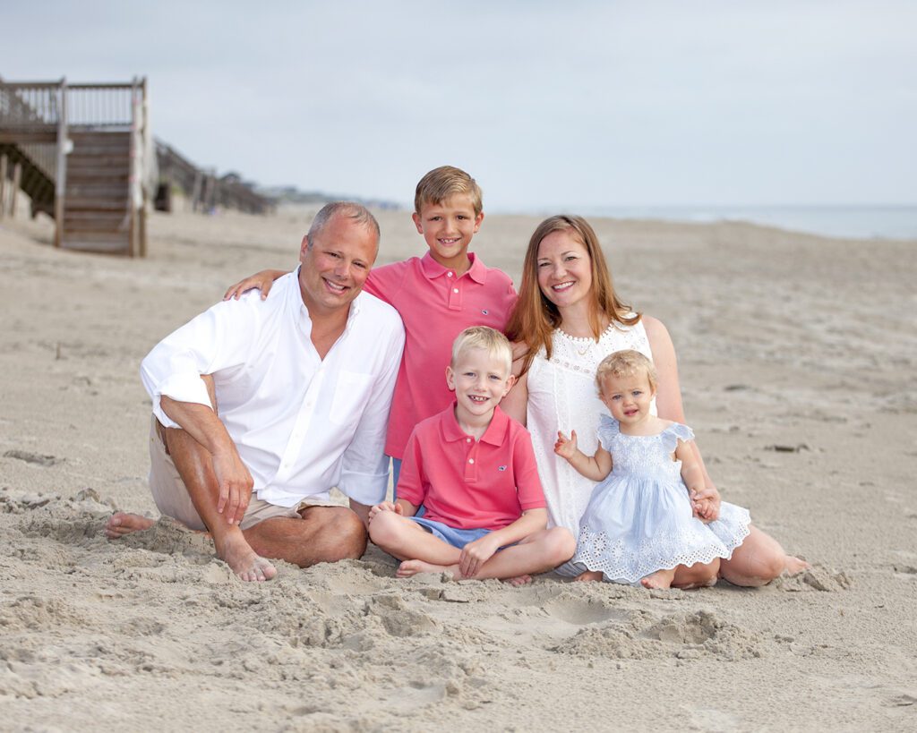 Family hugging together during golden hour portrait session in Corolla NC