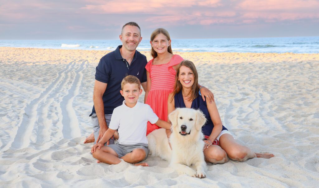 Family portrait on Carova 4x4 beach at sunset with ocean and dunes Outer Banks NC